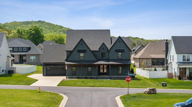 6913 Pembrooke Farms Dr, Murfreesboro, TN 37129 - view of front facade with driveway, fence, an attached garage, board and batten siding, and a front yard