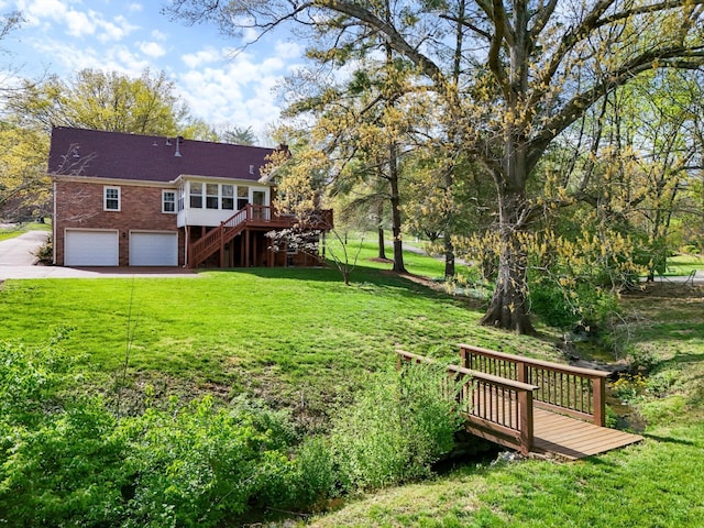 exterior space featuring concrete driveway, an attached garage, a wooden deck, and stairs