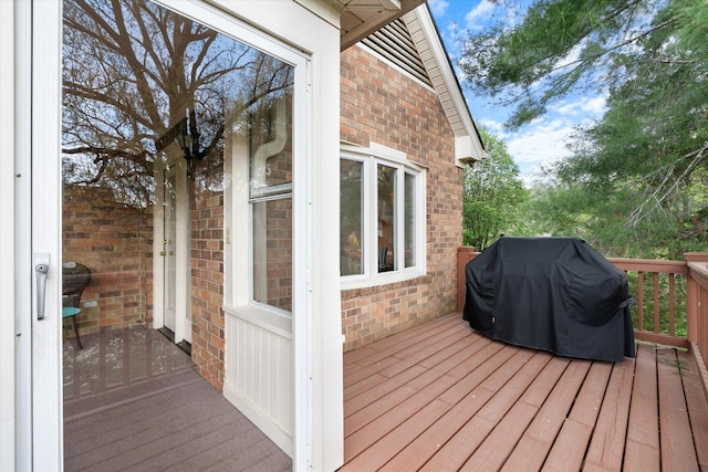 wooden deck featuring a grill