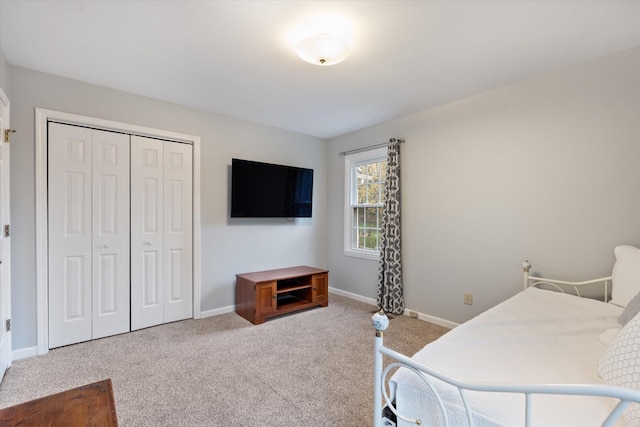 bedroom featuring carpet, a closet, and baseboards