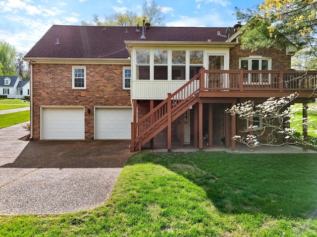back of property with a shingled roof, stairway, an attached garage, and a lawn
