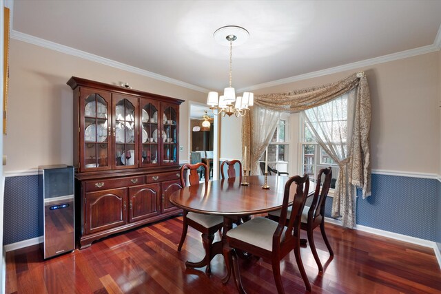 dining space with dark wood-type flooring, baseboards, an inviting chandelier, and ornamental molding
