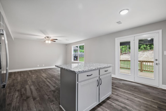 51 Gratton Ests, Clarksville, TN 37043 - kitchen with a ceiling fan, dark wood finished floors, baseboards, a kitchen island, and light stone countertops