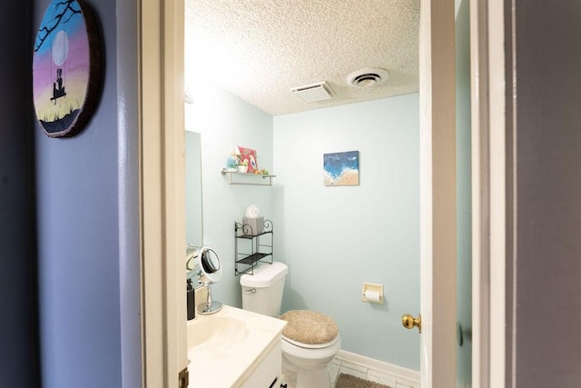 bathroom featuring a textured ceiling, vanity, visible vents, toilet, and tile patterned floors