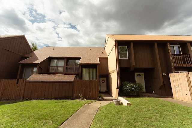 view of front facade with a front lawn and roof with shingles