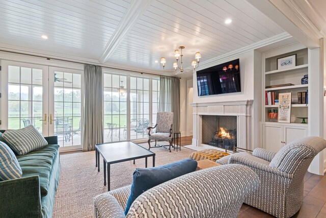 4535 Peytonsville Rd, Franklin, TN 37064 - living room with ornamental molding, a warm lit fireplace, a chandelier, built in shelves, and wood finished floors