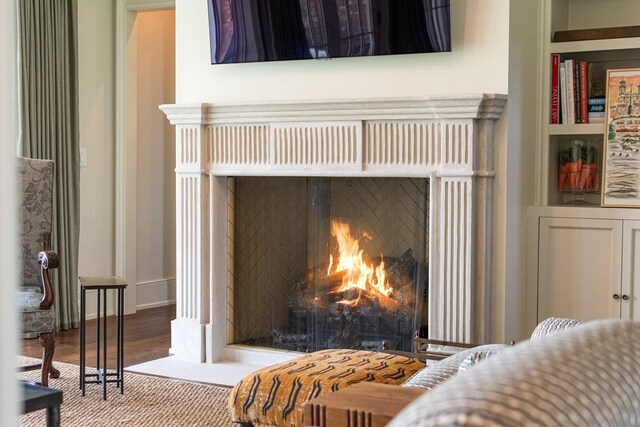 4535 Peytonsville Rd, Franklin, TN 37064 - room details with a warm lit fireplace, built in shelves, and wood finished floors
