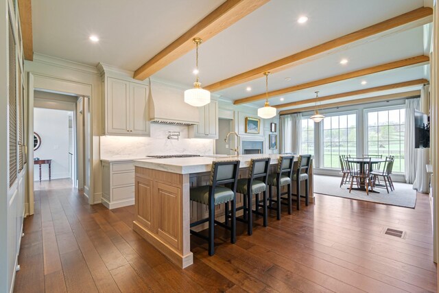 4535 Peytonsville Rd, Franklin, TN 37064 - kitchen with dark wood finished floors, visible vents, a breakfast bar, custom range hood, and a spacious island