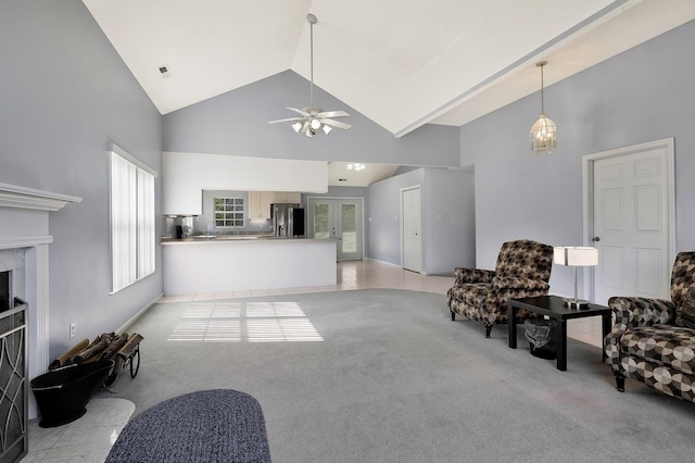 living area with baseboards, ceiling fan, high vaulted ceiling, a high end fireplace, and light colored carpet