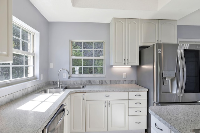 kitchen featuring stainless steel fridge with ice dispenser, a sink, light countertops, dishwashing machine, and white cabinetry