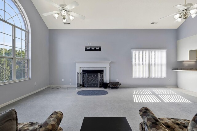 carpeted living room with visible vents, high vaulted ceiling, a ceiling fan, and a wealth of natural light