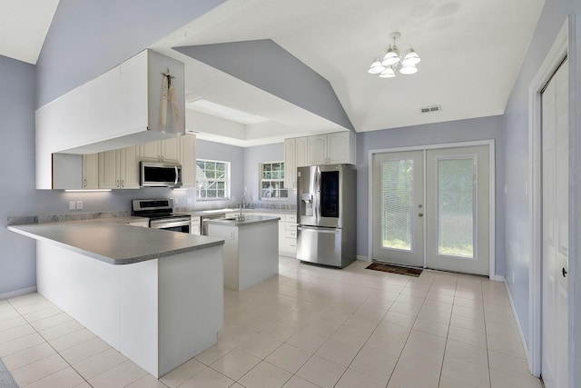 kitchen featuring a chandelier, a kitchen island, visible vents, lofted ceiling, and appliances with stainless steel finishes
