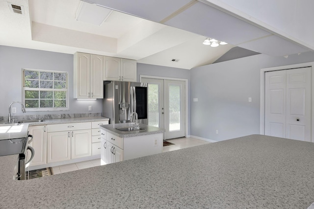 kitchen with stainless steel fridge with ice dispenser, light tile patterned floors, light countertops, and a sink
