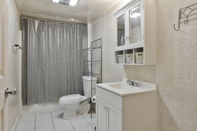 full bathroom with toilet, curtained shower, tile patterned flooring, and tile walls
