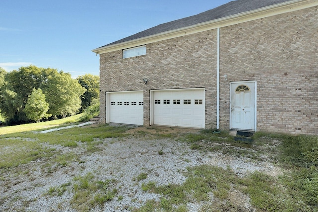 view of home's exterior featuring a garage and brick siding