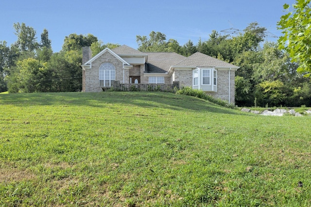 single story home with a front yard, brick siding, and a chimney