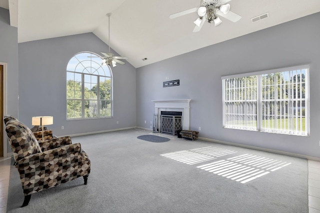 living room with visible vents, ceiling fan, carpet, a fireplace with flush hearth, and high vaulted ceiling