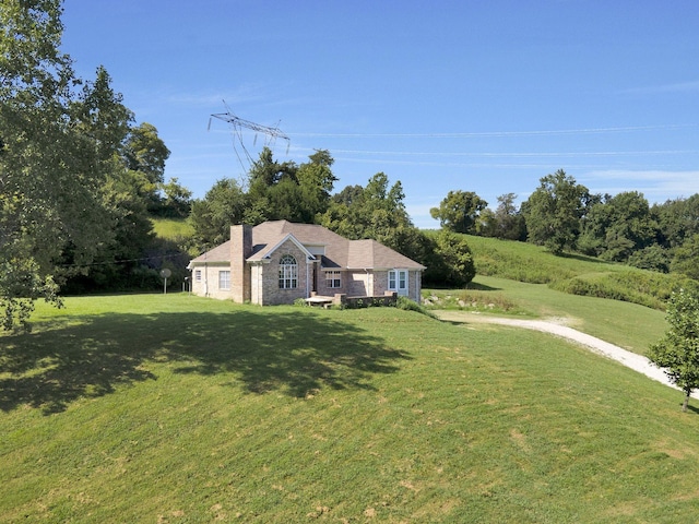 view of front of home with a chimney and a front yard