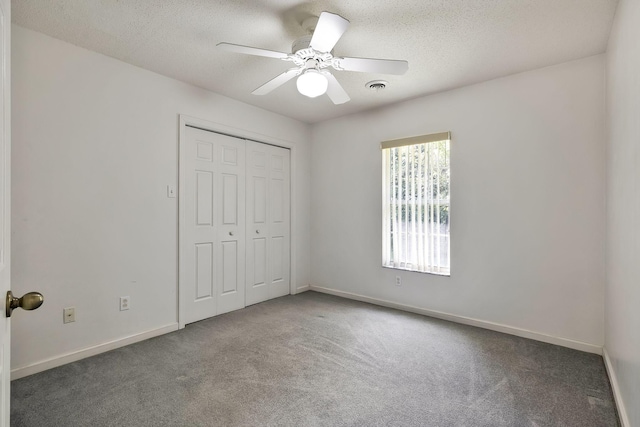 unfurnished bedroom featuring visible vents, baseboards, a closet, a textured ceiling, and carpet flooring