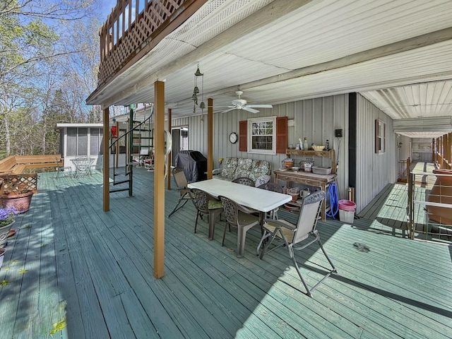 wooden terrace featuring outdoor dining space, a grill, a sunroom, and ceiling fan
