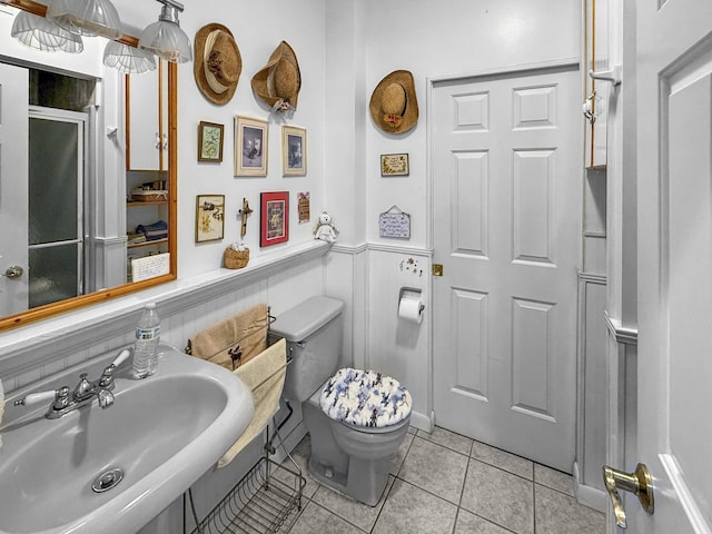 bathroom featuring a sink, tile patterned floors, and toilet
