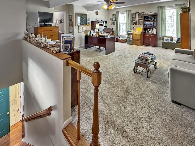 carpeted living area with ceiling fan