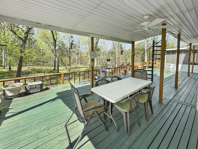 wooden terrace with a ceiling fan and outdoor dining area