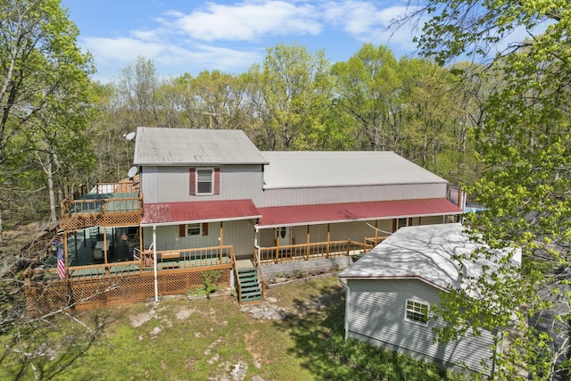 rear view of house with a deck and a lawn
