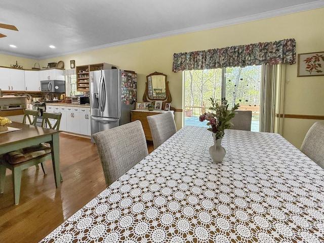 dining area with crown molding, wood finished floors, a ceiling fan, and recessed lighting