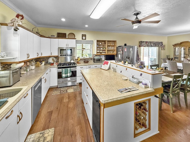 kitchen featuring light wood-style flooring, ornamental molding, a wealth of natural light, and stainless steel appliances