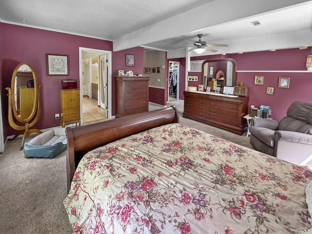 carpeted bedroom featuring visible vents, a spacious closet, ceiling fan, and ensuite bathroom