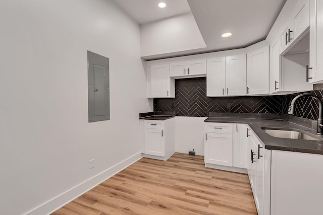 418 Mercomatic Dr, Nashville, TN 37209 - kitchen with a sink, electric panel, dark countertops, tasteful backsplash, and white cabinets
