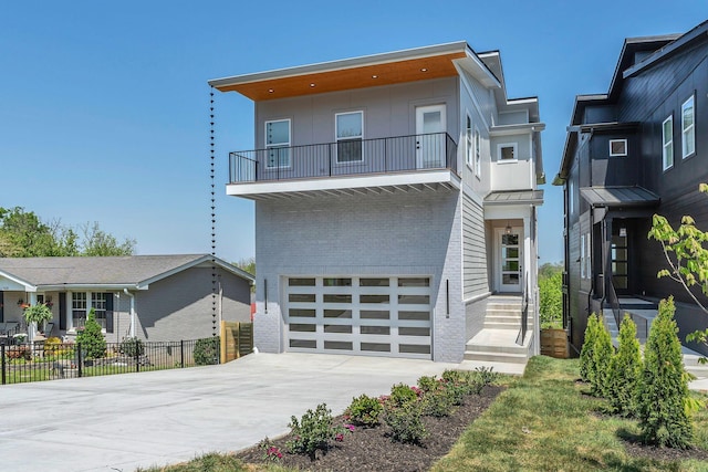418 Mercomatic Dr, Nashville, TN 37209 - contemporary house featuring a balcony, brick siding, a garage, fence, and driveway