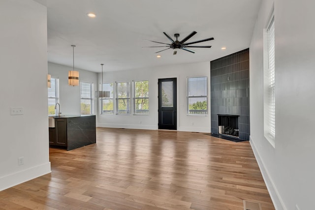 418 Mercomatic Dr, Nashville, TN 37209 - unfurnished living room with ceiling fan, baseboards, light wood-style flooring, recessed lighting, and a tiled fireplace