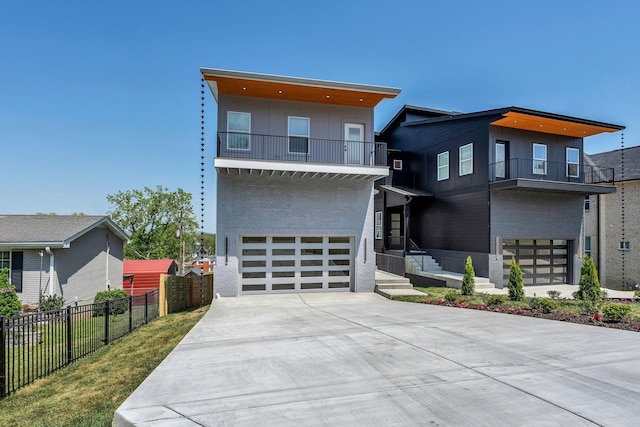 418 Mercomatic Dr, Nashville, TN 37209 - modern home featuring a balcony, brick siding, a garage, and driveway