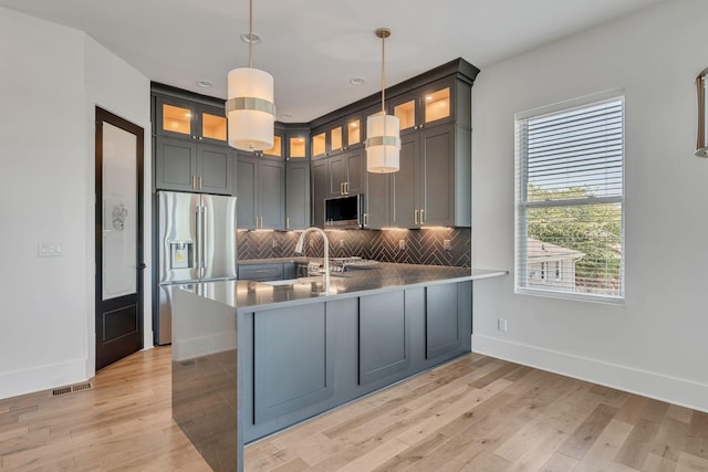 418 Mercomatic Dr, Nashville, TN 37209 - kitchen with appliances with stainless steel finishes, baseboards, a peninsula, a sink, and decorative backsplash