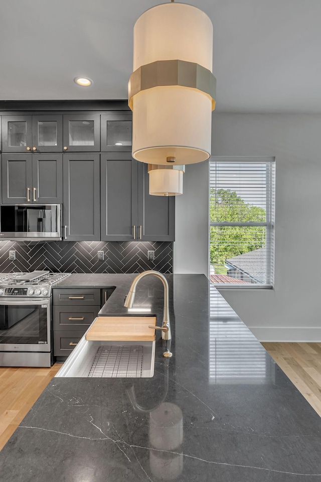 418 Mercomatic Dr, Nashville, TN 37209 - kitchen with stainless steel gas range oven, gray cabinetry, tasteful backsplash, light wood-style flooring, and recessed lighting