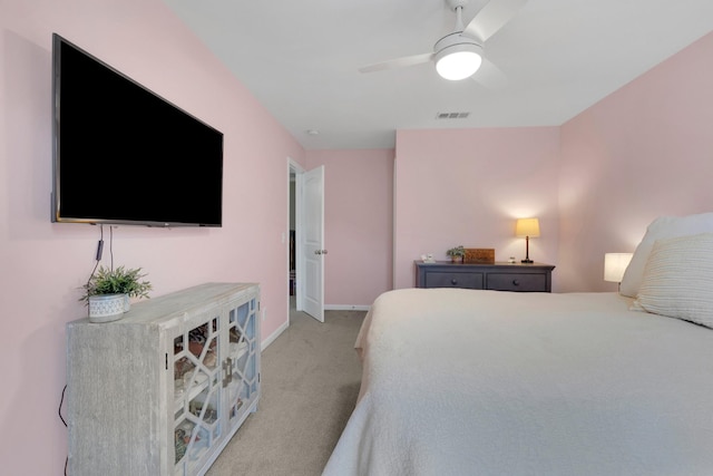 bedroom with visible vents, a ceiling fan, baseboards, and light carpet