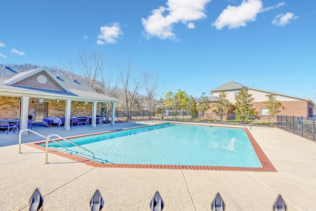 community pool with fence and a patio area