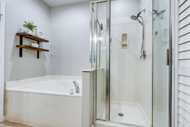 full bath with a bath and a shower stall