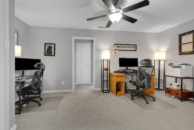 office featuring visible vents, light carpet, a ceiling fan, and baseboards