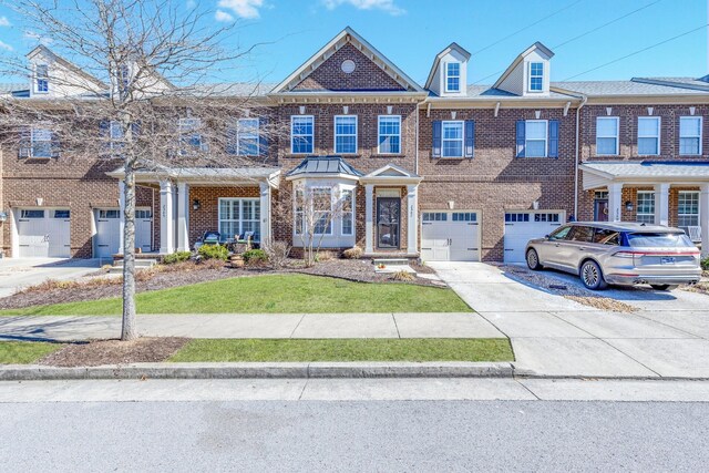 multi unit property featuring driveway, brick siding, a front yard, and a garage