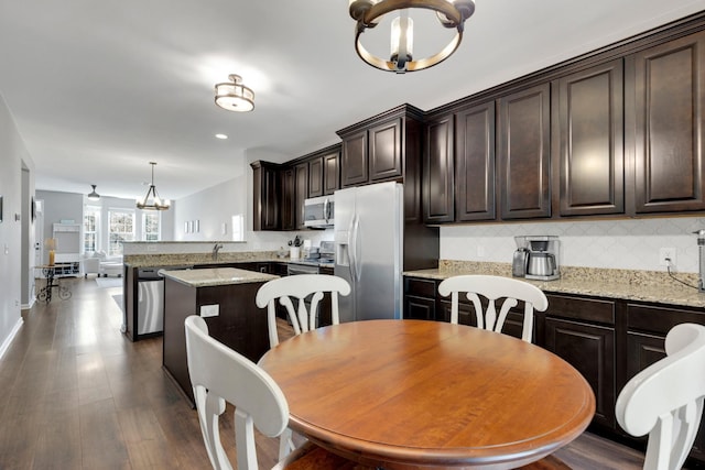 dining space featuring a chandelier, dark wood finished floors, baseboards, and recessed lighting