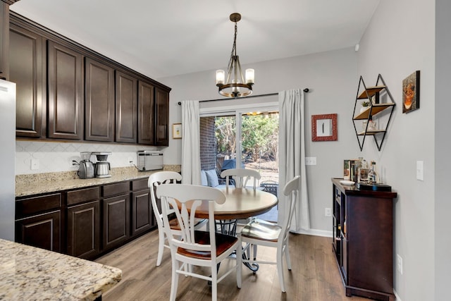 dining area with light wood-style flooring and a chandelier