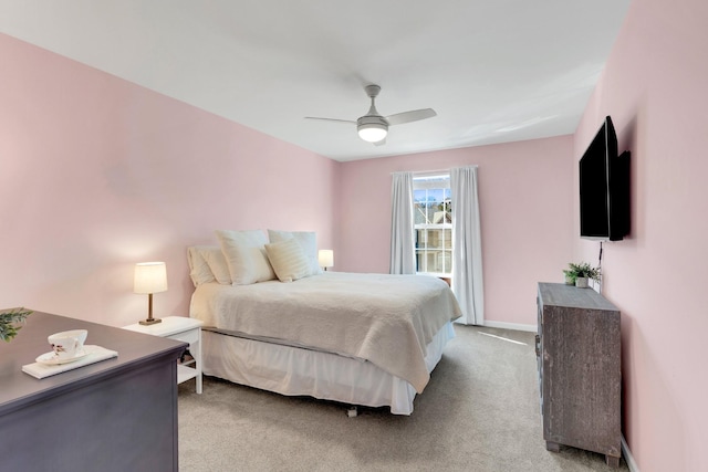 bedroom featuring light carpet, a ceiling fan, and baseboards