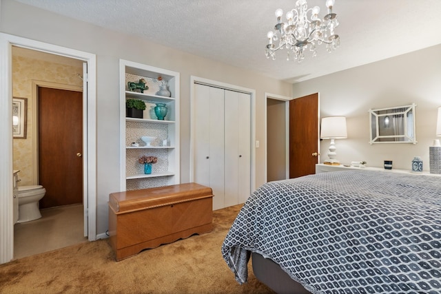 bedroom with a closet, carpet flooring, connected bathroom, and an inviting chandelier