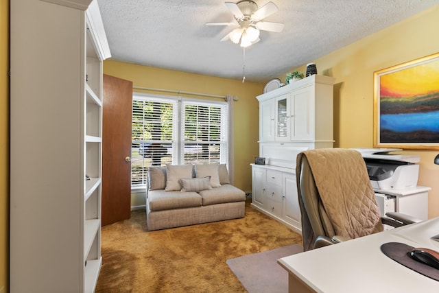 carpeted home office featuring a textured ceiling and a ceiling fan