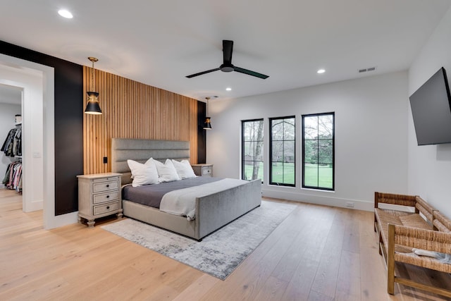 bedroom with recessed lighting, an accent wall, visible vents, and light wood-type flooring