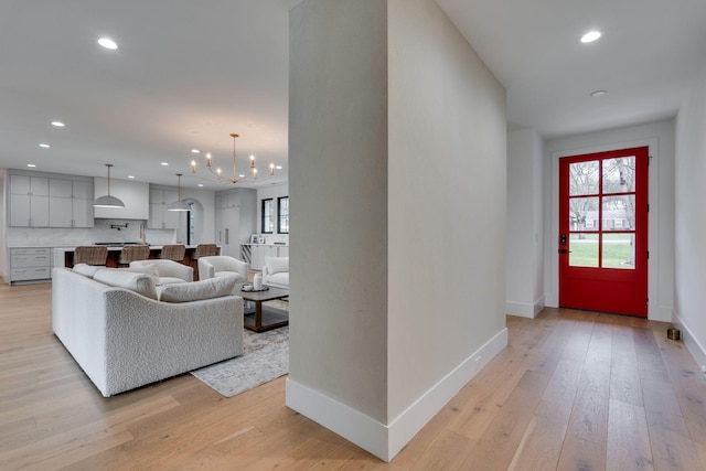 interior space featuring recessed lighting, light wood-style floors, a chandelier, and baseboards