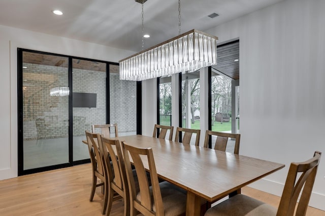 dining space with light wood-type flooring, visible vents, and recessed lighting